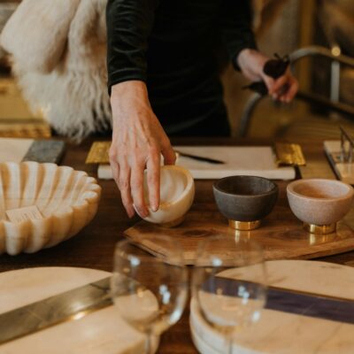 A person selects decorative bowls and tableware in a cozy retail setting.