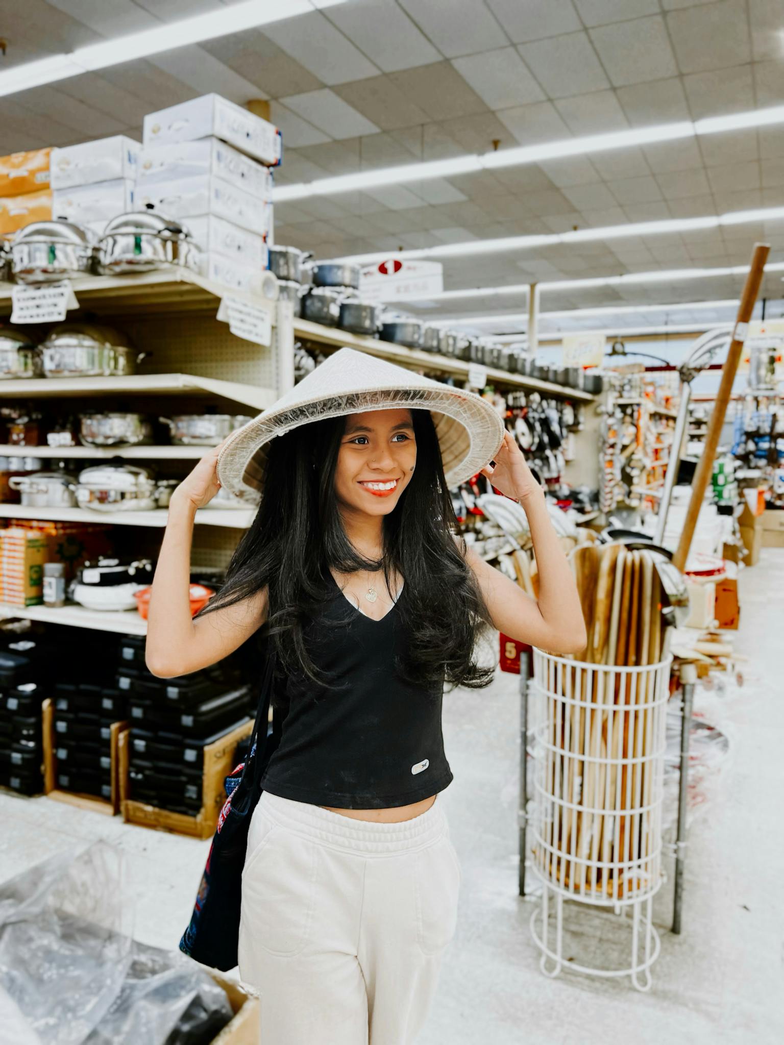 Smiling woman wearing a conical hat in a Dallas supermarket, enjoying shopping.